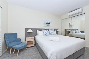 Un dormitorio con una cama y una silla azul. en Pacific Blue Unit 175 Dual Swim Up, en Salamander Bay 24 fotos más