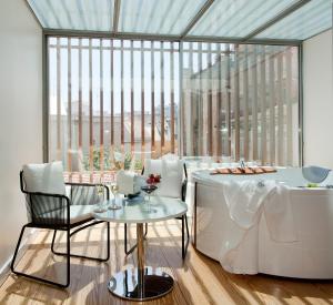 a dining room with a tub and a table and chairs at Inspira Liberdade Boutique Hotel in Lisbon