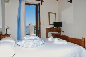 a bedroom with a bed with towels and a television at Kamares Studios in Symi