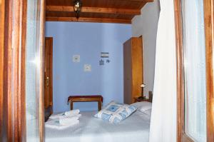a bedroom with blue walls and a bed with towels at Kamares Studios in Symi