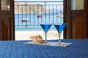 two glasses on a table with a view of the ocean at Kamares Studios in Symi