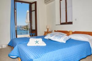 a bedroom with a blue bed with a towel on it at Kamares Studios in Symi