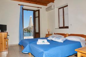 a bedroom with a blue bed and a window at Kamares Studios in Symi