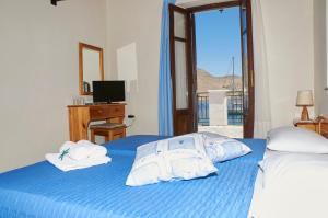 a bedroom with two beds with towels and a window at Kamares Studios in Symi