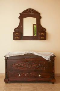 a wooden dresser with a mirror on a wall at Kamares Studios in Symi