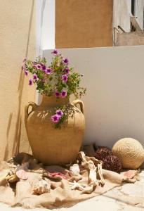 a vase with flowers in it sitting on a table at Kamares Studios in Symi