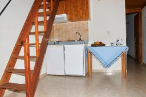 a kitchen with a ladder next to a white refrigerator at Kamares Studios in Symi