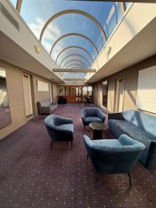 a room with couches and chairs and a ceiling at Parkview Hotel in Orange