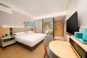 une chambre avec un lit, un bureau et une télévision dans l'établissement City Comfort Inn Liuzhou Luzhai Walking Street, à Luzhai