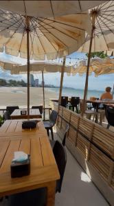 two tables and chairs with umbrellas on the beach at Ging's Beach & Pool in Hua Hin +20 photos