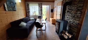 a living room with a couch and a table at Domki Nad Liliowym Stawem in Berezka
