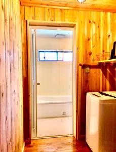 ein Badezimmer mit einer Tür, die zu einer Badewanne führt. in der Unterkunft 淵明庵 in Fujikawa