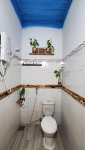 a bathroom with a toilet with a blue ceiling at LoCo House in Con Dao