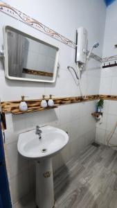 a bathroom with a sink and a mirror at LoCo House in Con Dao