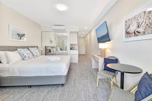 a hotel room with a bed and a table and chairs at Pacific Blue Unit 175 Dual Swim Up B in Salamander Bay