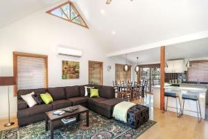 Una sala de estar con un sofá y una cocina. en Blackwood Chalet, en Merrijig