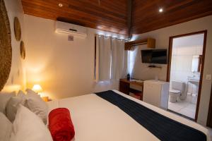 a bedroom with a large bed and a bathroom at Pousada Ventos da Atalaia in Fernando de Noronha