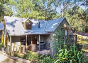 una pequeña casa con porche y techo azul en Blackwood Chalet, en Merrijig