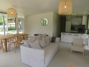 a living room with a couch and a table and a kitchen at Changue Buller Views in Merrijig