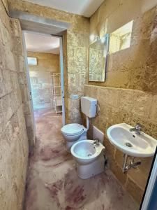 a bathroom with two sinks and a toilet and a mirror at Li Monaci - GALLIPOLI - EcoBio RELAIS in Gallipoli