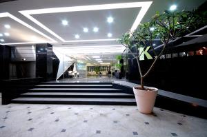 a plant in a pot in a lobby with stairs at Kapok Hotel & Resorts in Luodong