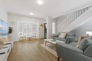 a living room with a couch and a table at Beachside 3-Bed Retreat with BBQ & Garage in Glenelg