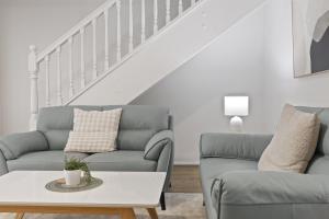 a living room with two couches and a table at Beachside 3-Bed Retreat with BBQ & Garage in Glenelg