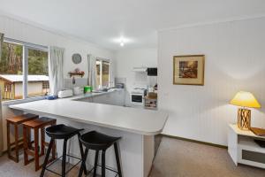cocina con encimera blanca grande y taburetes de bar en CLUB SNOWFLAKE, en Mount Buller