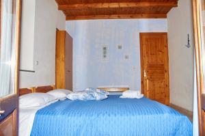 a bedroom with a blue bed with two pillows at Kamares Studios in Symi