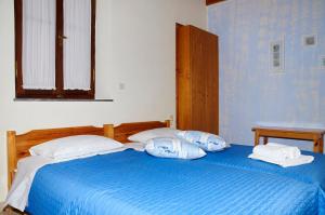 a bedroom with two beds with blue sheets and white pillows at Kamares Studios in Symi