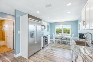 a kitchen with a stainless steel refrigerator and a table at 106 La Riviere Rd in Cocoa Beach