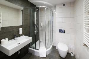 a bathroom with a shower and a sink and a toilet at Apartamenty Turek in Turek