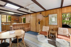a living room with wooden walls and a table and chairs at Milly @ Sawmill in Mount Buller