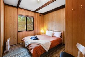 Un dormitorio con una cama en una habitación con ventana. en Milly @ Sawmill, en Mount Buller