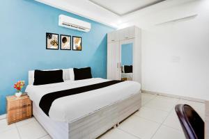 a bedroom with a large bed and a blue wall at Super Townhouse Subhash Chowk Near Medanta Hospital Formerly L B Residency in Gurgaon