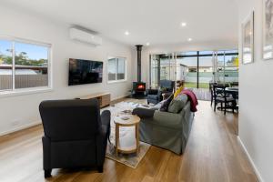 a living room with a couch and chairs and a table at Timber Mill Cottage in Mansfield