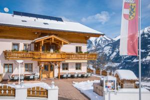 a building with a balcony in the mountains at Hotel-Pension Lackenbauer in Bad Hofgastein