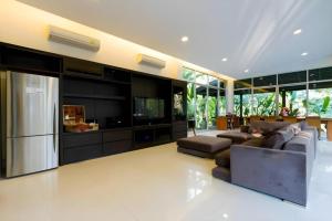 ein Wohnzimmer mit Sofa und Fernseher in der Unterkunft Khao Yai Paradise on Earth in Ban Bung Toei