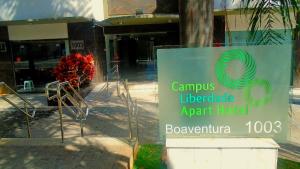 a sign in front of a building with agraduate agent hotel at Campus Liberdade Flat in Belo Horizonte