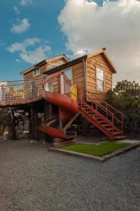 NogalCrows Nest Treehouse At El Mistico Ranch的前面有滑梯的房子