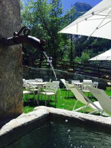 a person is hanging off the side of a water fountain at Shatush Hotel in Courmayeur