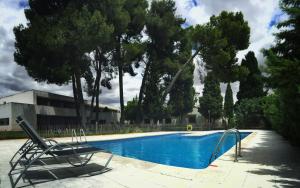 Hotel & Spa La Salve في توريخوس: كرسي بجانب مسبح به اشجار