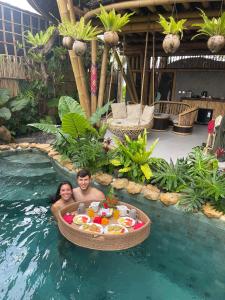 a man and a woman in a boat in the water at The Queen Bamboo Ubud in Ubud