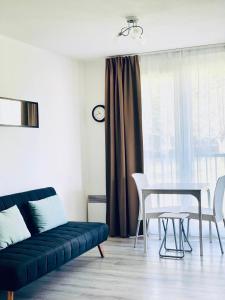 un salon avec un canapé bleu et une table dans l'établissement Apartment - Equemauville - Normandie, à Équemauville