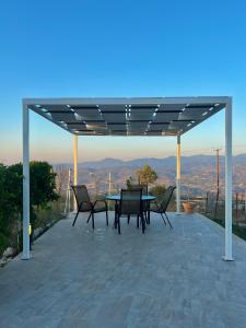 a table and chairs on a patio with a view at Villa Terra Rosa in Kritou Terra