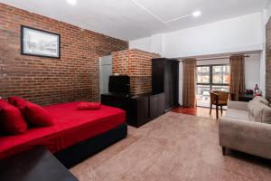 a bedroom with a red bed and a brick wall at Trillium Boutique Express Hotel - Ward Place in Colombo