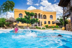 una niñita jugando en el agua en una piscina en Zan View Hotel en Kiwengwa