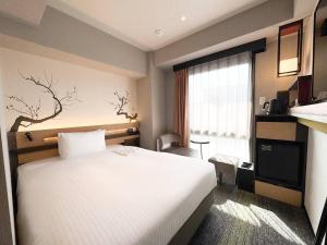 ein Hotelzimmer mit einem Bett und einem Fenster in der Unterkunft Shizutetsu Hotel Prezio Kyoto Karasumaoike in Kyoto