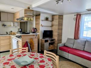 ein Wohnzimmer mit Tisch und Küche in der Unterkunft Mobil home Apollon Riviera in Saint-Papoul