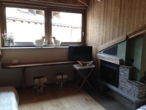 Habitación con chimenea y 2 pájaros sentados en el alféizar de la ventana en LTHorses & Dreams, en La Thuile